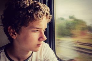 Teenage boy looking out the window of the train